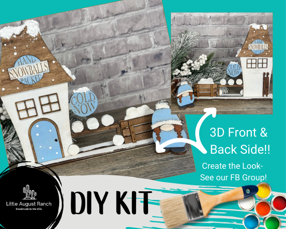 A DIY kit with the Christmas Village Self Standing Double sided Pieces - SNOWBALL FACTORY - Winter Village Wood Blanks and a paint brush for creating a Christmas Village.