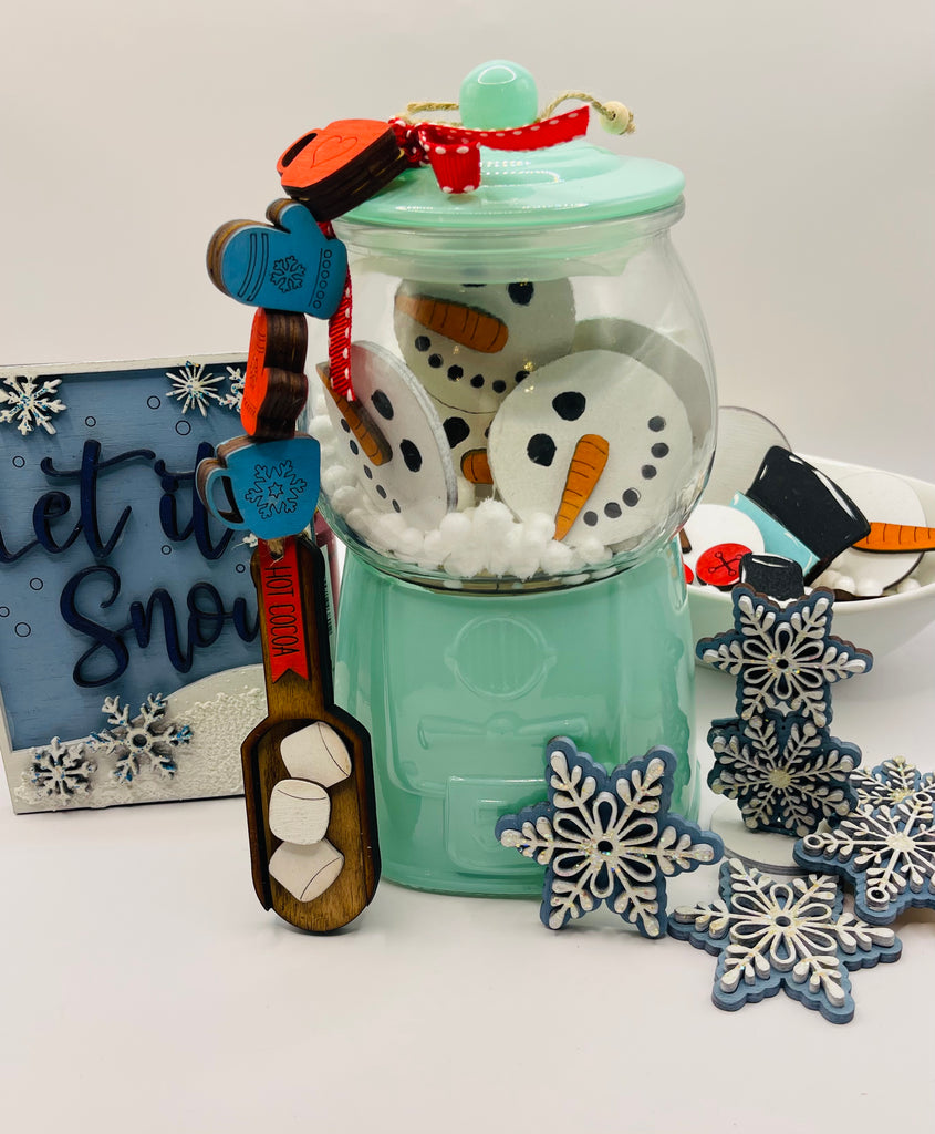 A Winter Gumball Machine Filler - DIY Gumball Filler Craft Kit - Wood Blanks by Little August Ranch is next to a snowman shaped cookie jar.