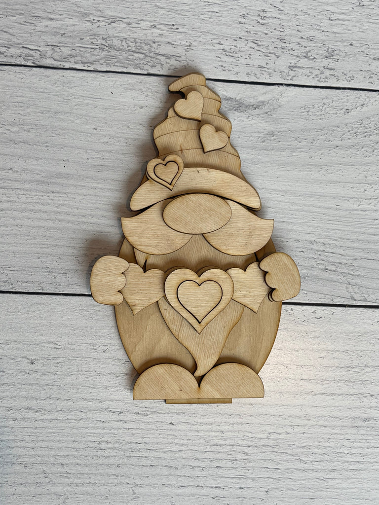 This Valentine Love Gnome DIY - Standing Gnome on Base - DIY Paint Kit by Little August Ranch includes a wooden gnome that you can DIY paint, holding a heart.