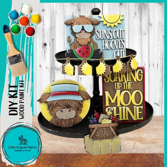 A colorful, whimsical DIY kit for a tiered tray decor set featuring cartoon donkeys with summer and bedtime themes, wood pieces, paint supplies, and branding elements. Summer Highland Cow Tiered Tray DIY Kit - Quick and Easy Tiered Tray Bundle by Lit