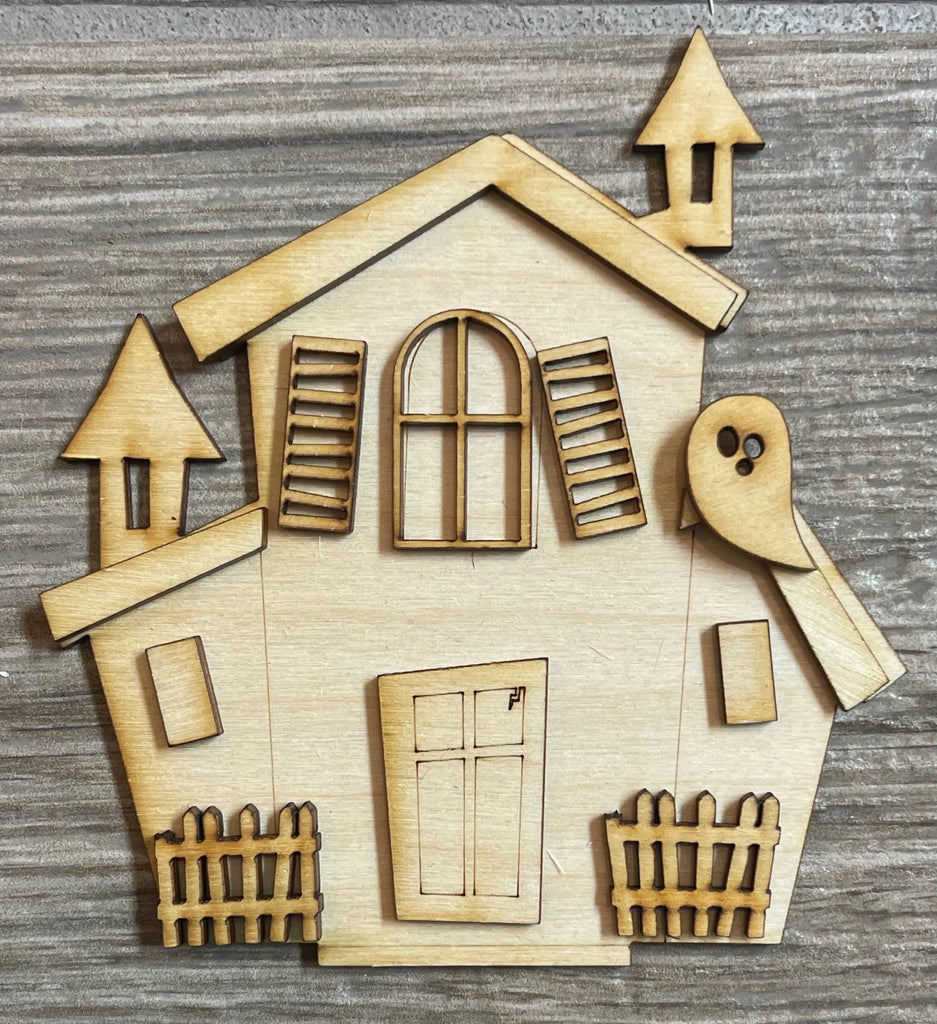 A DIY Halloween Village Standing Pieces - Haunted Village - Halloween Shelf Decor Blank Kit - Graveyard, Spooky House, Ghost Wood Blanks house cut out on a wooden surface.