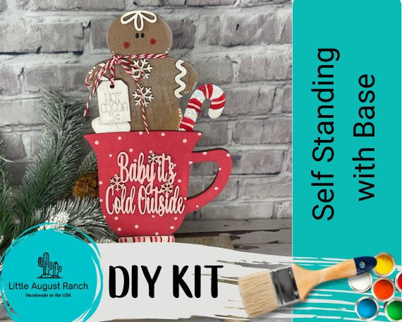 A Gingerbread Hot Cocoa DIY - Standing Decor Base in a mug with a paintbrush for DIY wood crafts by Little August Ranch.