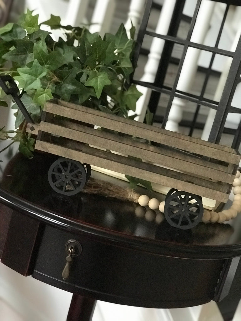A small, colorful DIY Mini Wagon - Tiered Tray Mini Base from Little August Ranch on top of a table.