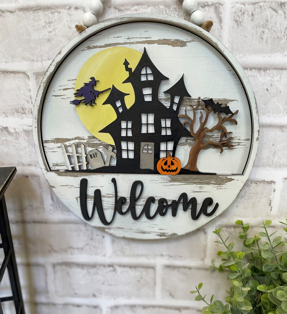 An interchangeable wooden welcome sign with a house and bats on it, perfect as a DIY Interchangeable Door Hanger - Halloween Insert for the Little August Ranch Interchangeable - Paint it Yourself insert for an interior sign or as a unique door hanger.