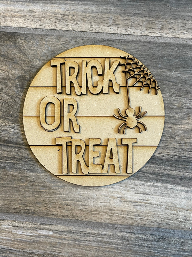 A spooky Little August Ranch Halloween wooden sign that says trick or treat, perfect for your DIY Halloween Tiered Tray - Candy Corn Tier Tray Bundle or adding rustic charm to your decor.
