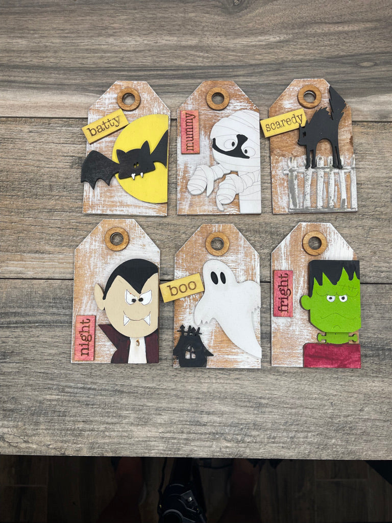 A set of Little August Ranch DIY Halloween Tags- Tree Ornament Wood Blanks - Traditional Halloween - Halloween Wood Pieces Paint Kit with different characters on them.