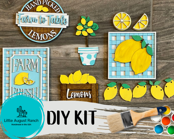 DIY craft kit with Lemon Tiered Tray DIY Paint Kit - Farmers Market Wood Blanks - U-Pick- Summer Paint Kit - Summer Wood Blanks wooden cutouts, paint, and a brush on a wooden background, labeled "Little August Ranch Farmers Market Paint Kit.
