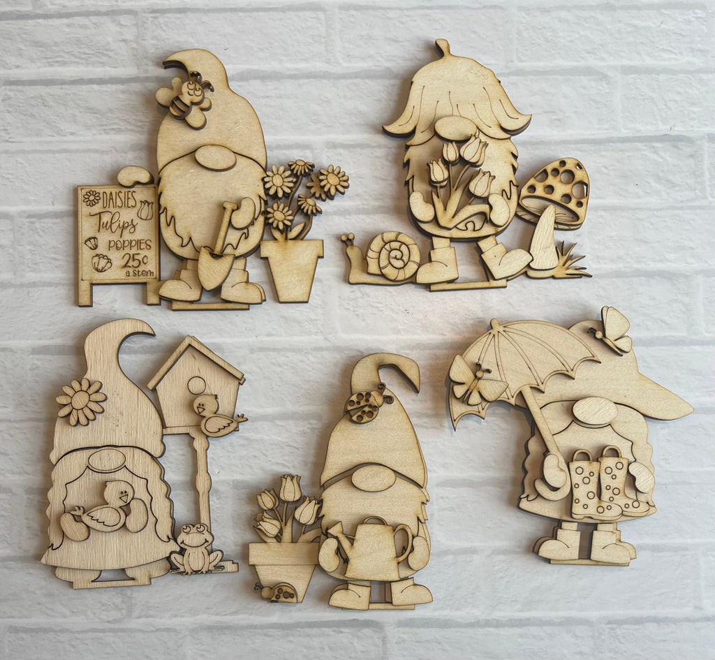 Four wooden Spring Gnome Standing Gnome Kits - Tiered Tray Gnomes - Paint it Yourself - DIY Springs by Little August Ranch on a brick wall.