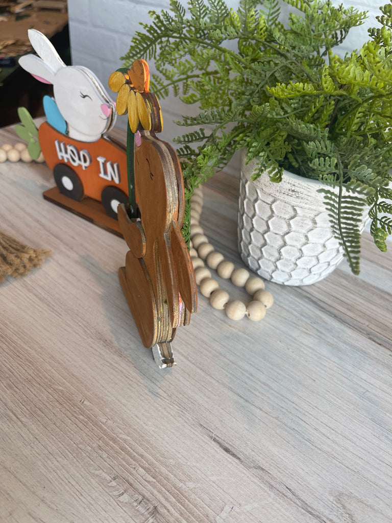A Carrot Car and Flower Holder Spring Bunny from Little August Ranch sitting on a wooden table, accompanied by a Bunny with Daisy.