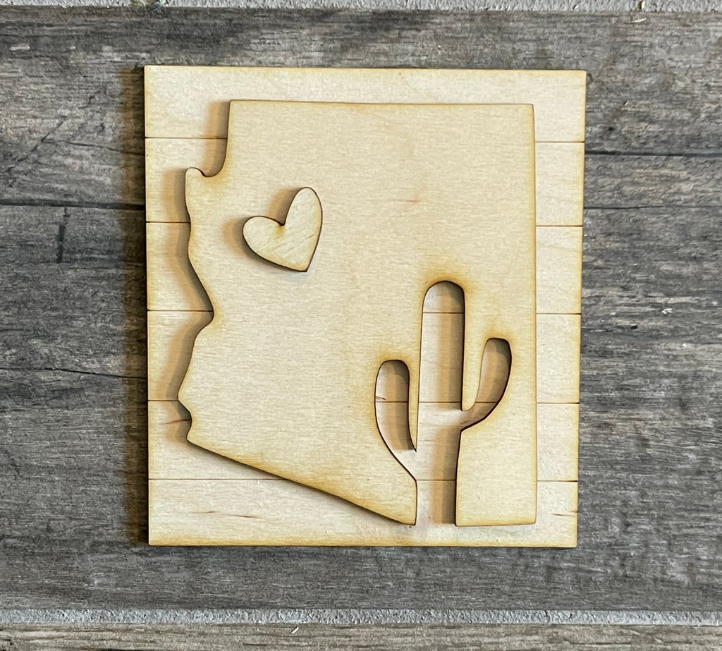 Create your own Arizona state cutout with a touch of charm using this Little August Ranch DIY paint kit. Featuring a striking cactus design and a heart motif, this unique Arizona Tiered Tray Decor Bundle DIY - State Decor - Arizona State Flag Decor - Arizona Wood Blanks - Cactus Wood Blanks will surely add a delightful touch.