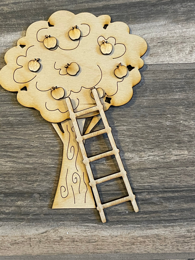 A wooden tree with a ladder and apples on it, painted using the Apple Tiered Tray DIY Paint Kit - Farmers Market Wood Blanks - U-Pick- Summer Paint Kit by Little August Ranch for a rustic and charming DIY look.