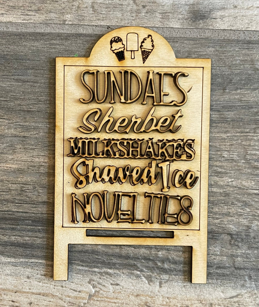 A DIY-painted wooden sign displaying the words "Sundays Sherbert Ice Cream" on a Little August Ranch DIY Ice Cream Shop Tiered Tray with unique wood pieces.