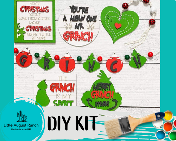 A Little August Ranch Christmas DIY Kit Set - Mean One Christmas, with a paint brush and paint.