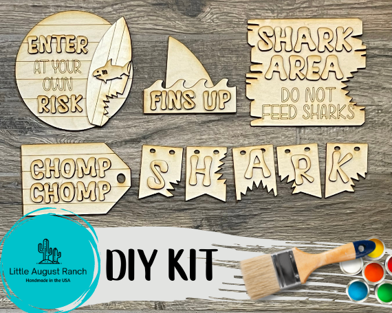 A DIY kit with a Shark Tiered Tray - Shark Week Themed Tiered Tray - Beach Decor - Fins Up, a paint brush, and a paint brush from Little August Ranch.