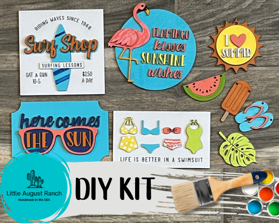 A collection of colorful DIY Summer Beach Tiered Tray craft cutouts and a paintbrush, labeled as a Little August Ranch paint kit.