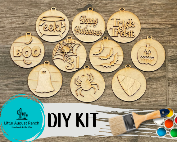 A set of DIY Halloween Ornament Wood Blanks - Traditional Halloween Tree Ornaments with a paint brush by Little August Ranch.