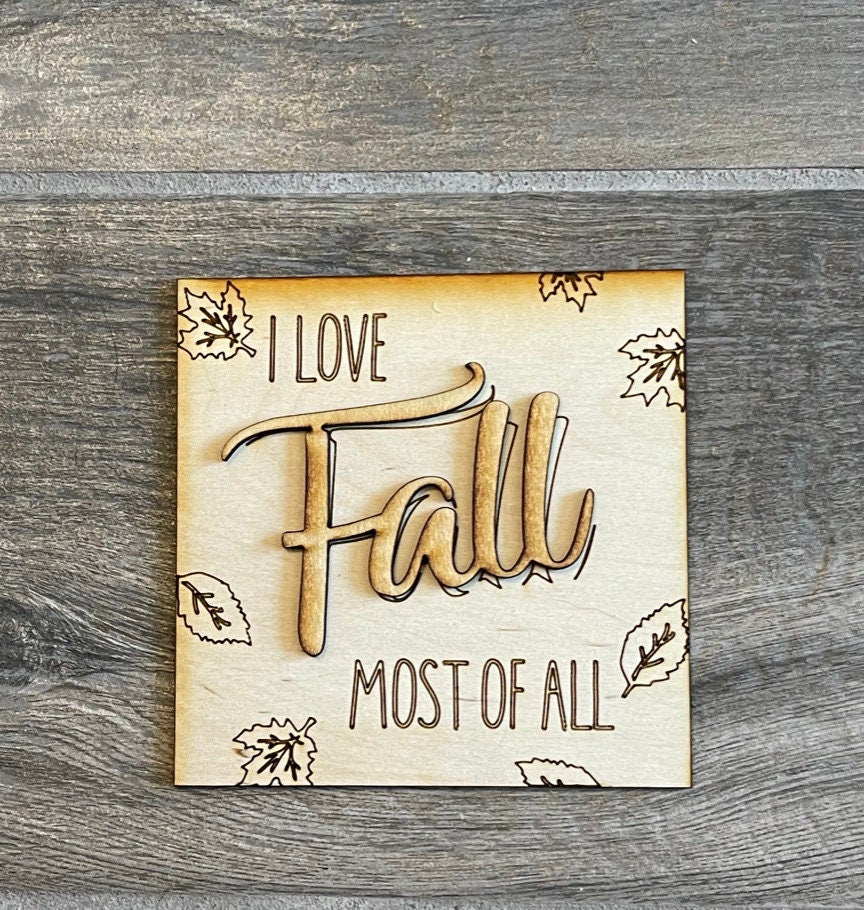 A wooden sign that says "I love fall most of all" and is perfect for your Tiered Tray Fall DIY - Leaning Ladder Insert Kit from Little August Ranch.