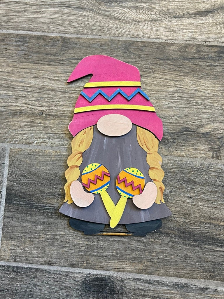A paper cut out of a Fiesta Freestanding Wood Gnome Outfit- Cinco de Mayo Interchangeable Gnomes gnome wearing a hat from Little August Ranch.