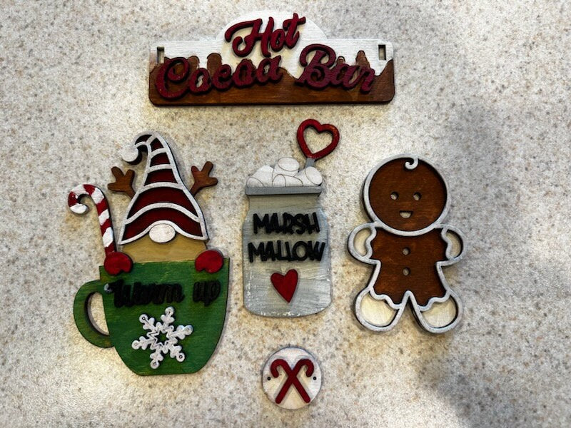 A group of Hot Cocoa Insert DIY ornaments from Little August Ranch on a table.